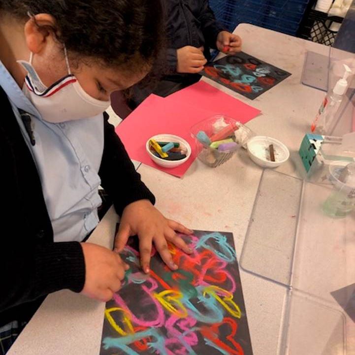  Student drawing colorful hearts on a page 